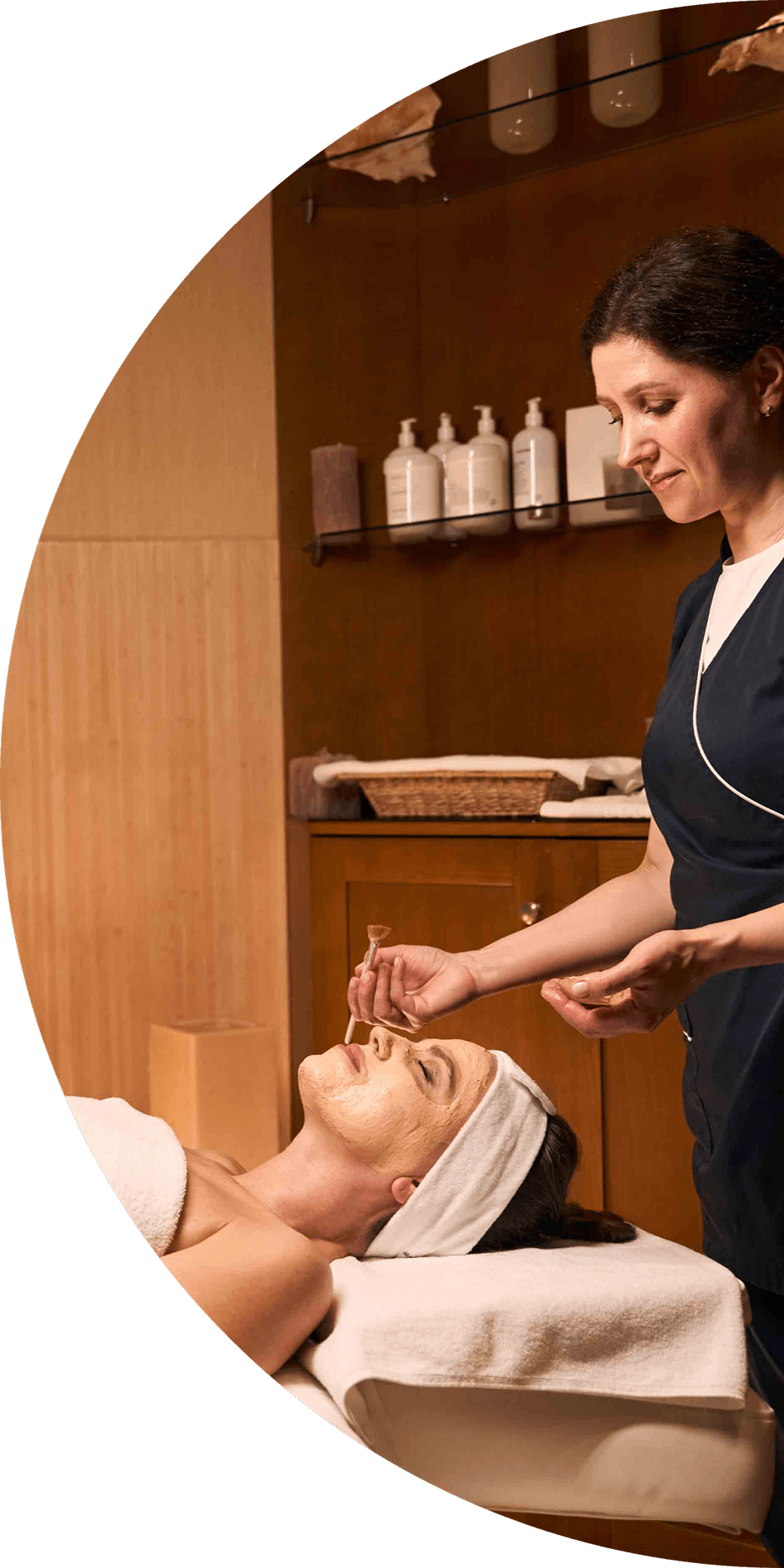 A woman giving another woman a facial treatment in a spa