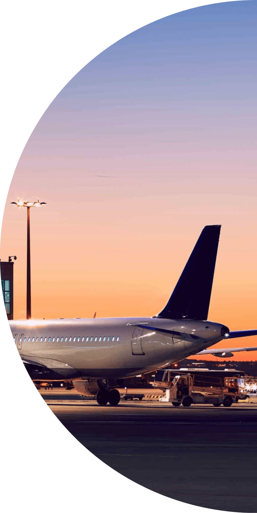 A plane parked at an airport at sunset