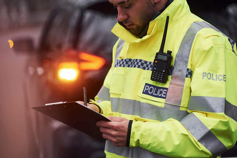 Law enforcement officer writes report after car accident