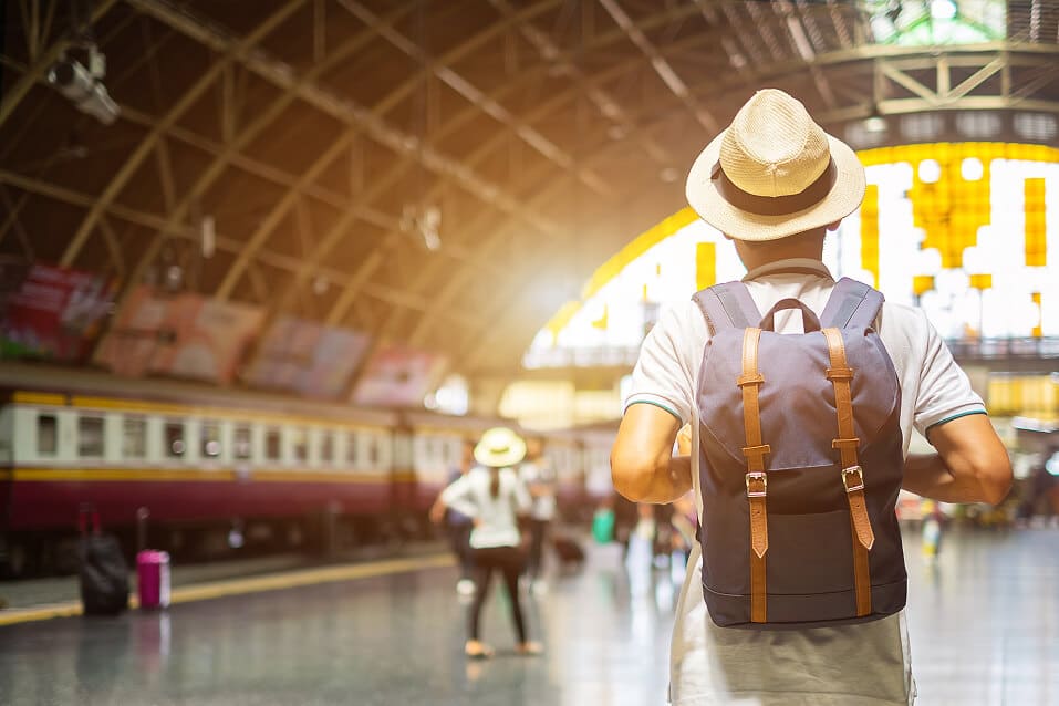 Man traveller with backpack waiting for train