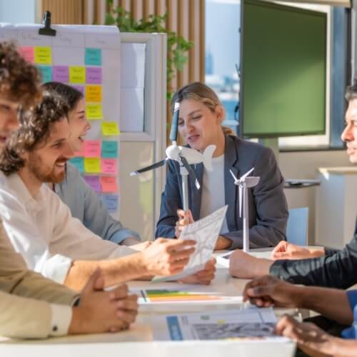 People discussing ideas around a desk